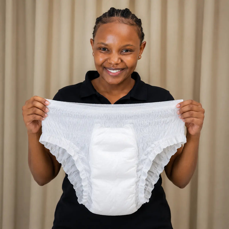 Woman holding Moyo Comforts white sanitary pants designed for secure, comfortable and full-coverage period protection.