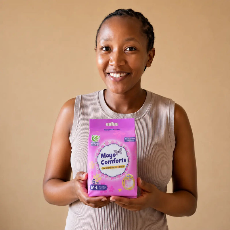 Smiling African woman presenting a Moyo Comforts sanitary pants pack for dependable period comfort and protection.